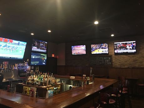 A bar with a lot of televisions on the wall