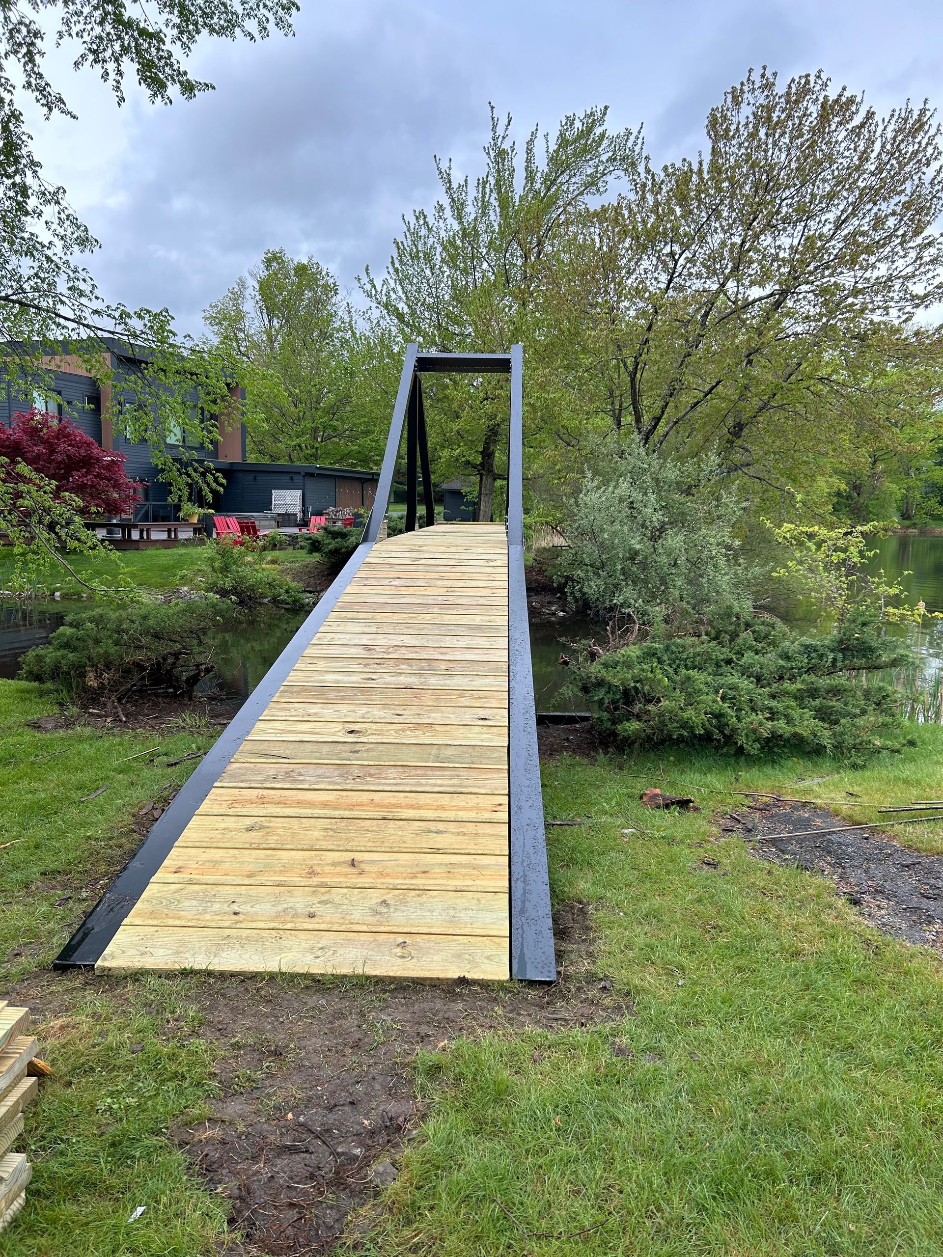 A wooden bridge is sitting in the middle of a grassy field
