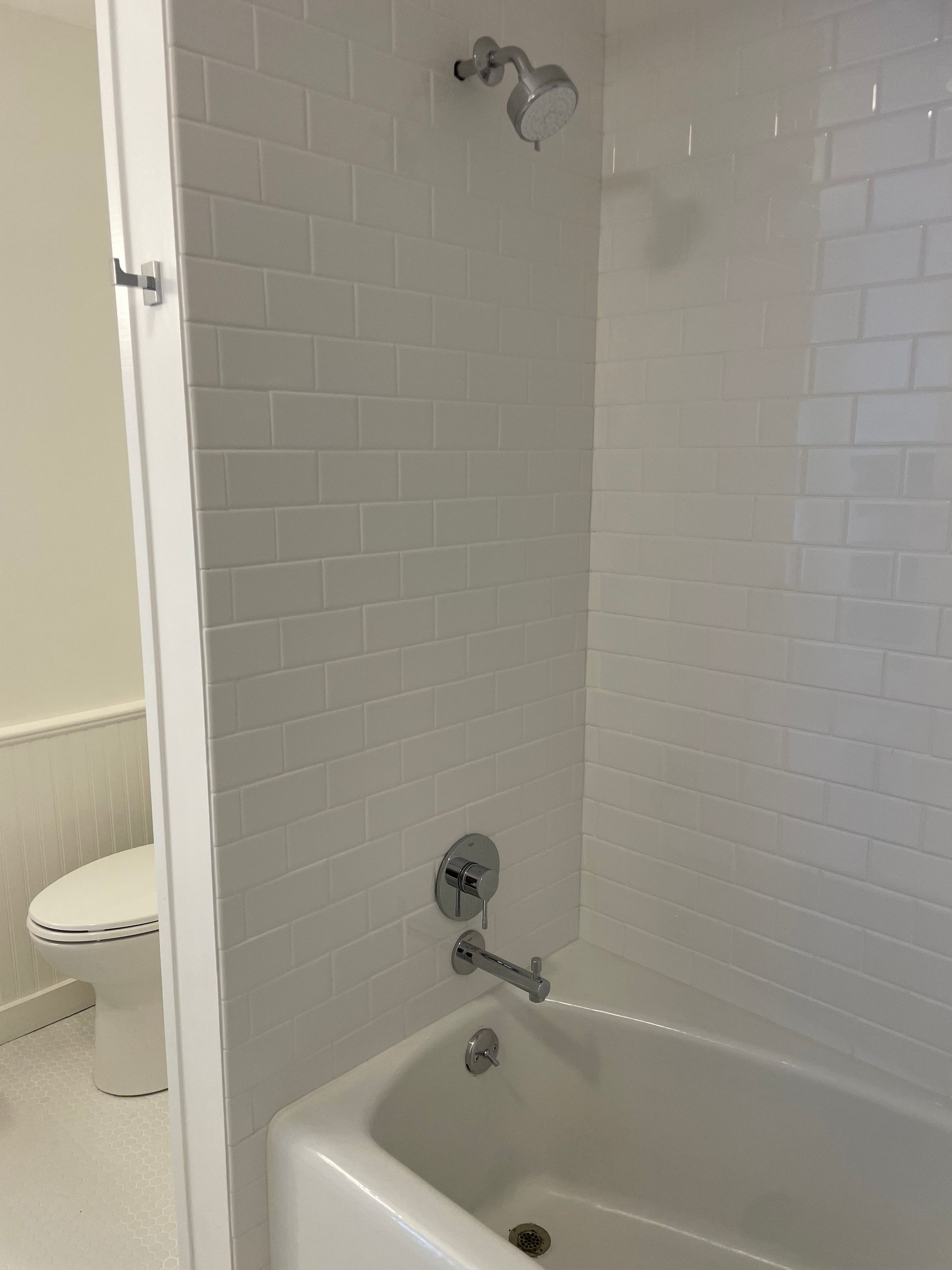 A bathroom with a bathtub , toilet and shower