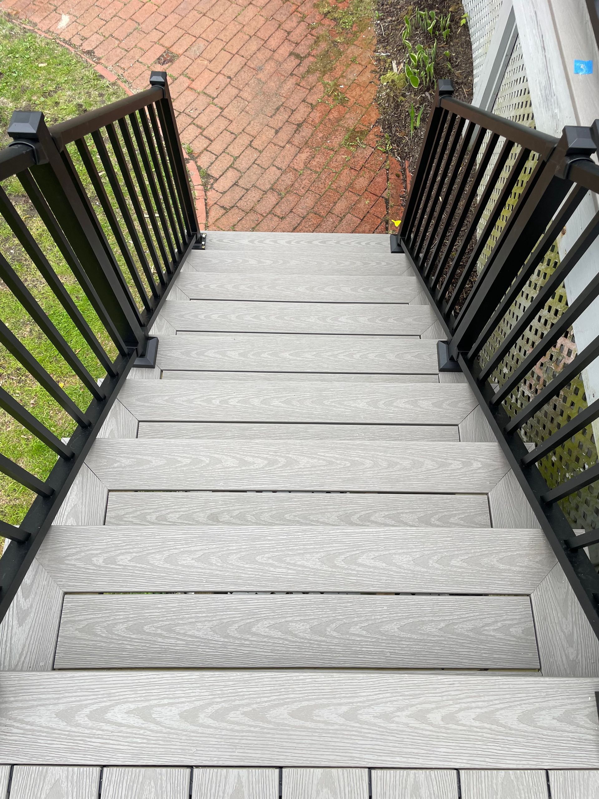 A set of stairs leading up to a deck with a black railing