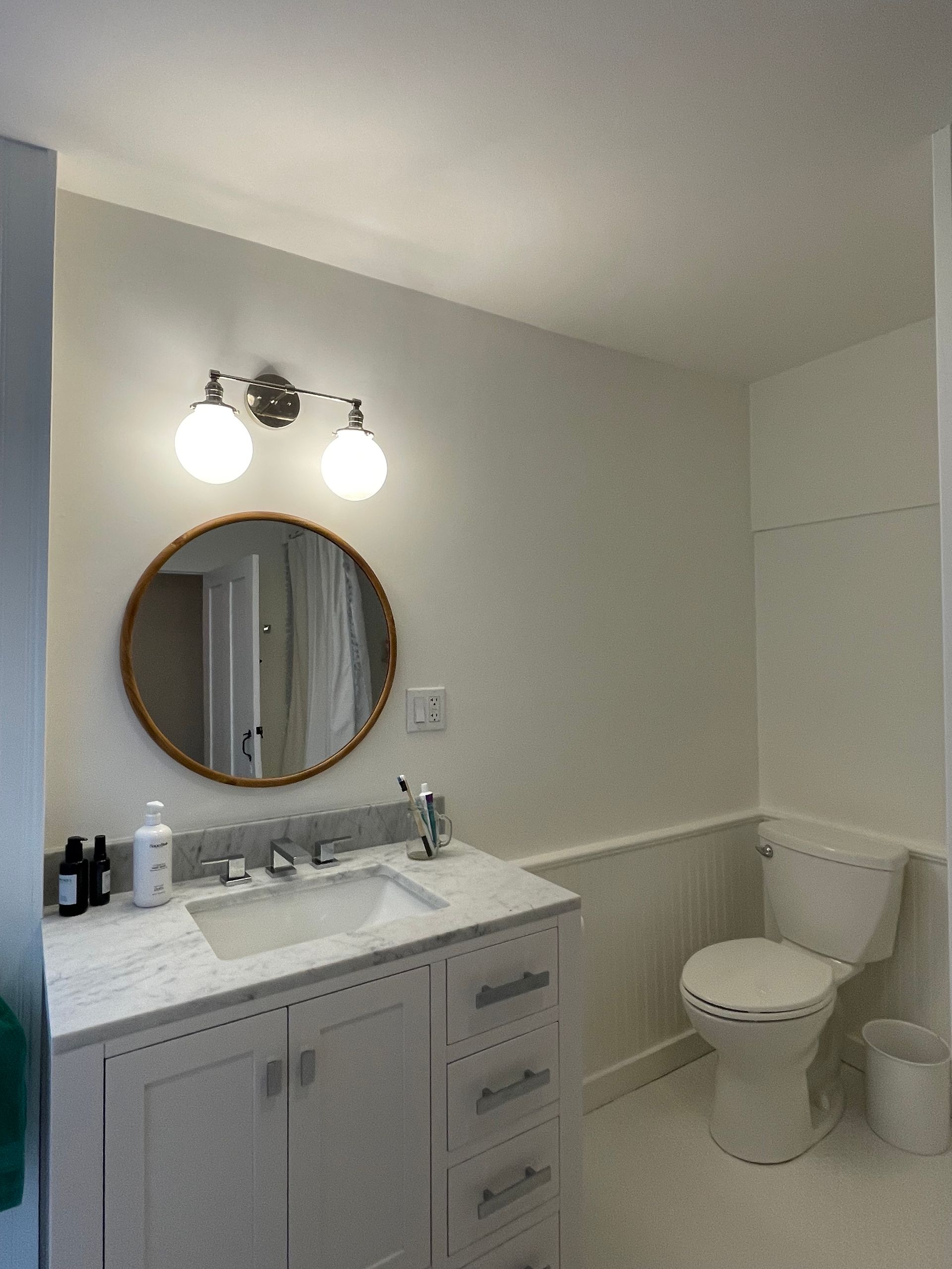 A bathroom with a sink , toilet and mirror