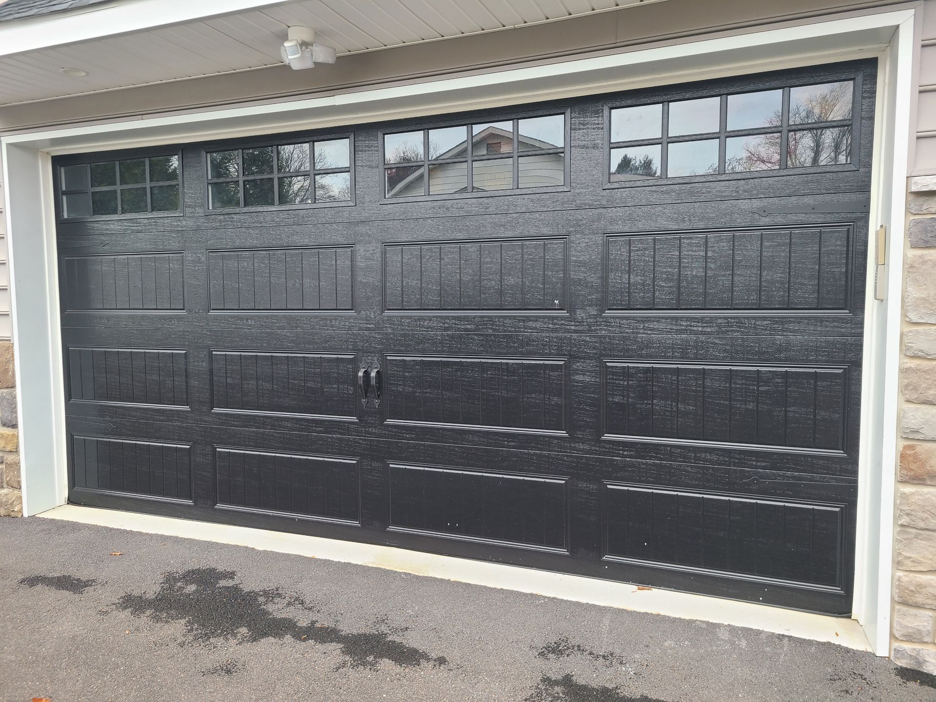 Black garage door with glass panel windows.