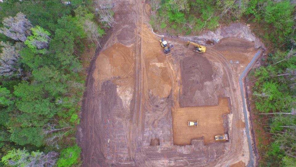 An aerial view of a construction site in the middle of a forest.