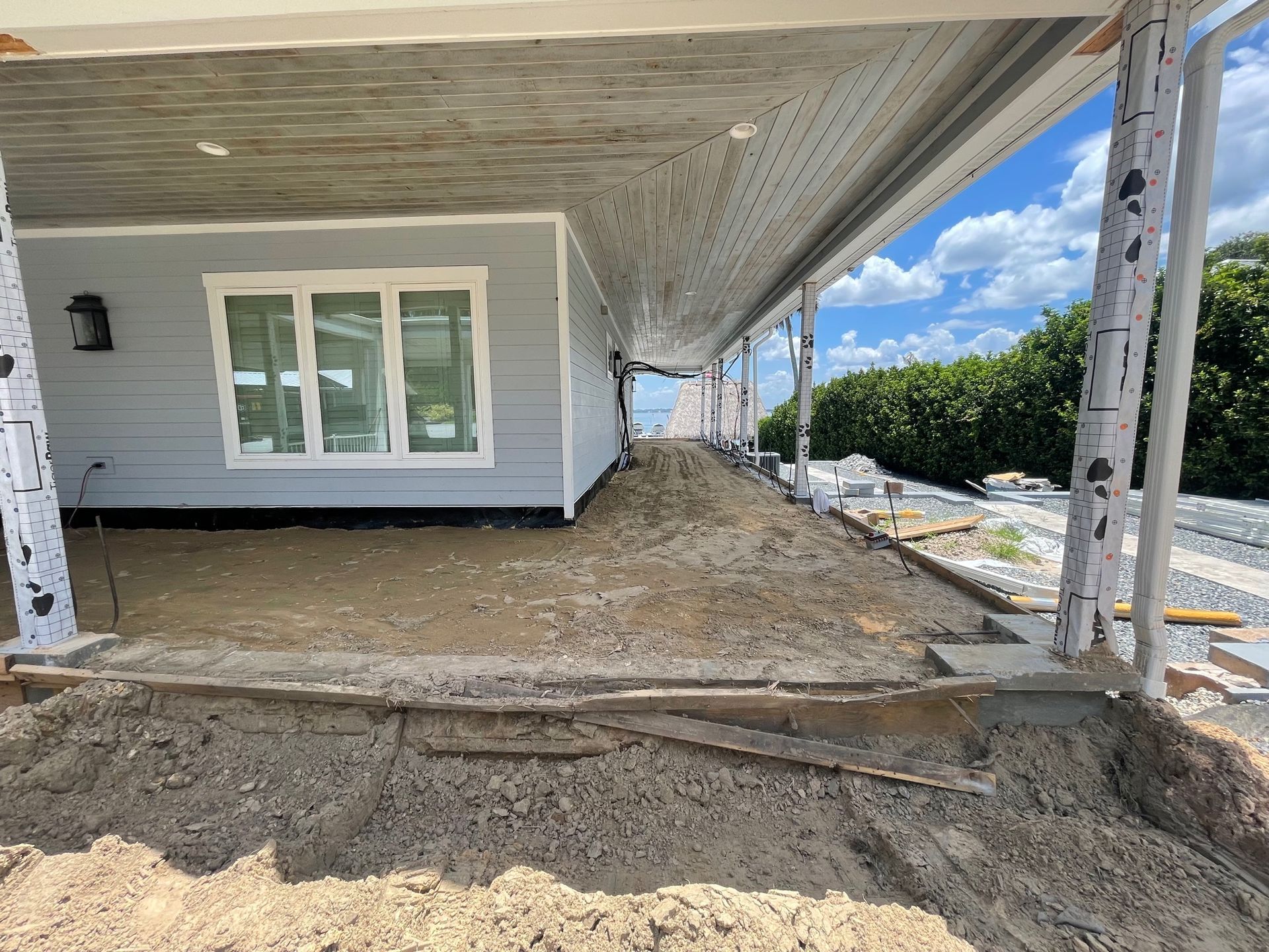 A house under construction with a lot of dirt in front of it.