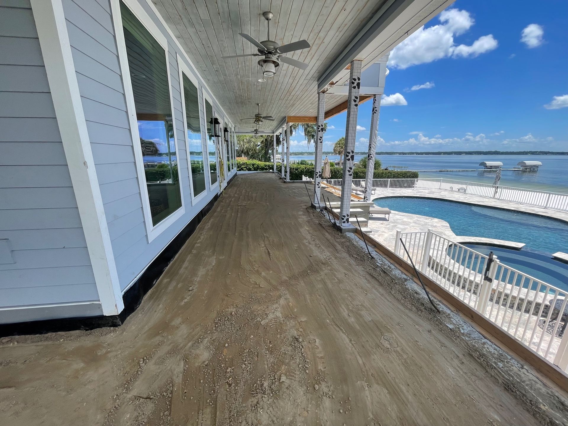 A large porch with a view of the ocean and a swimming pool.