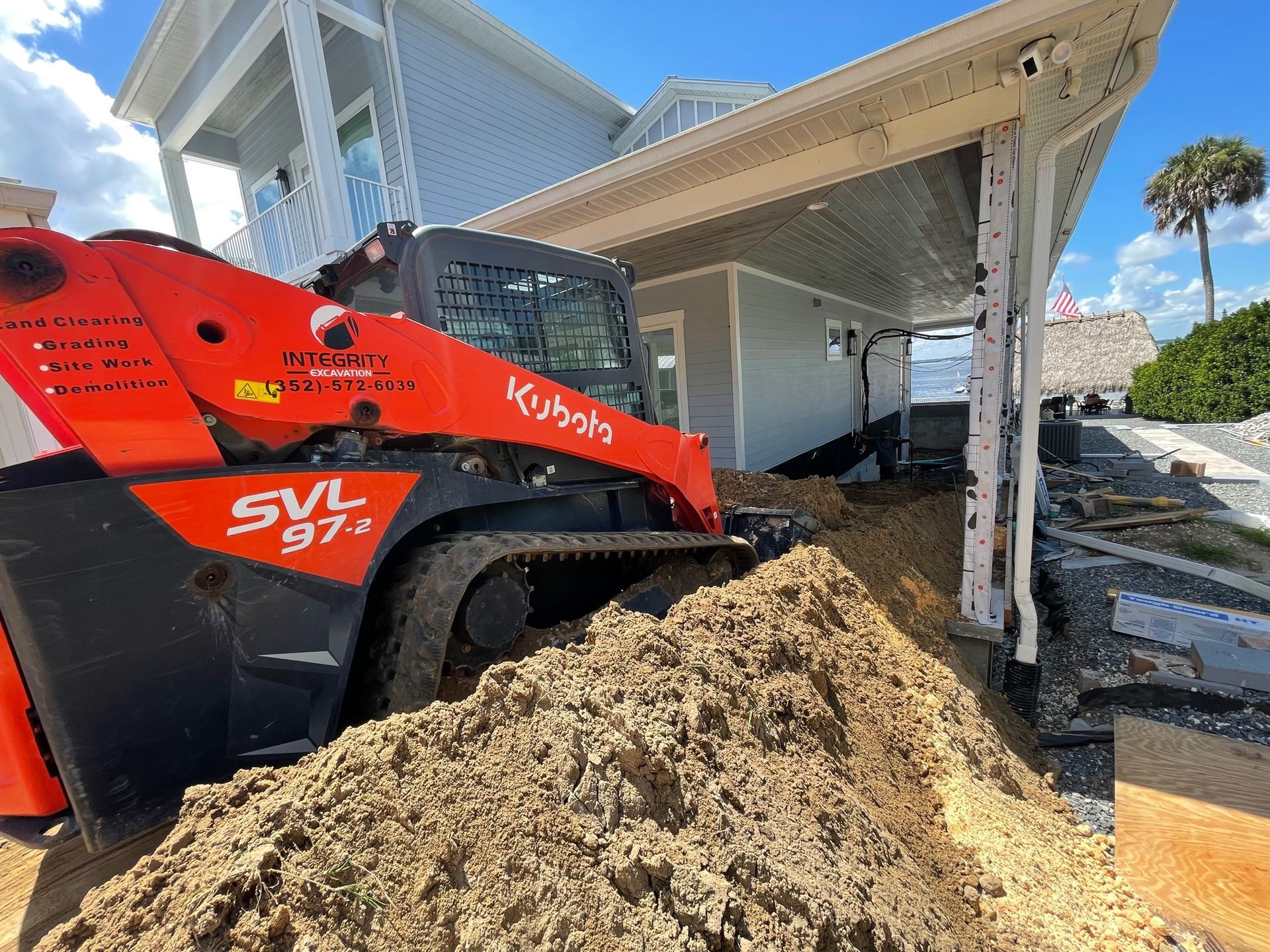 A bulldozer is moving dirt in front of a house.