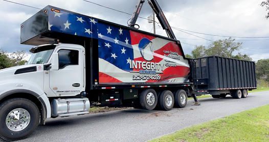 A garbage truck is parked on the side of the road.