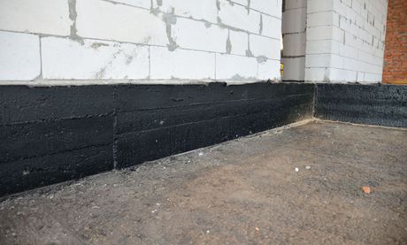 a corner of a building with a black foundation