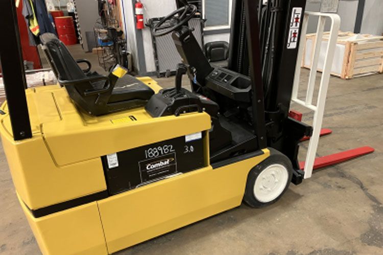 A yellow forklift is parked in a garage.