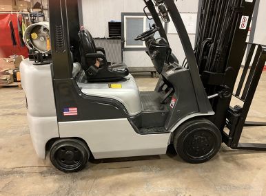 A forklift is sitting on the ground in a warehouse.