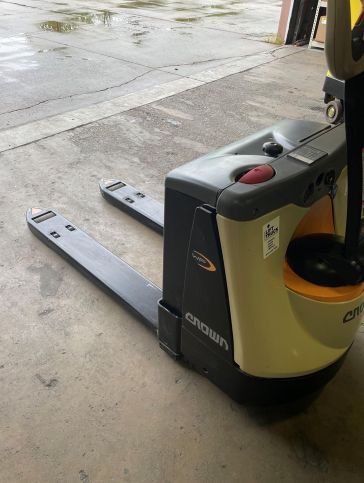 A forklift is sitting on the ground in a parking lot.