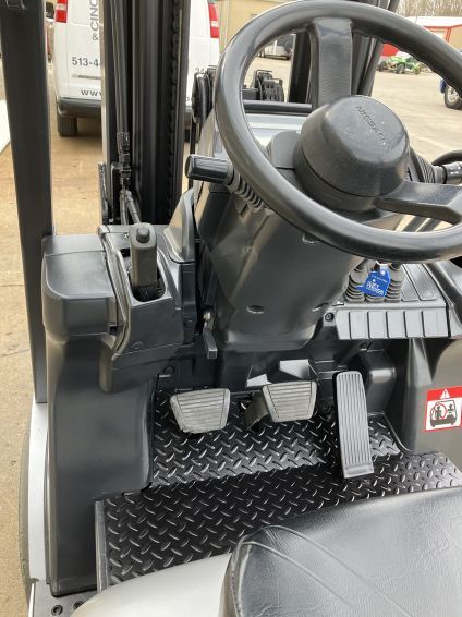 A forklift with a steering wheel and pedals