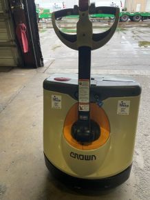 A forklift is sitting on the ground in a warehouse.