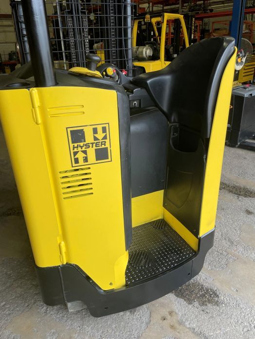 A yellow and black forklift is parked in a warehouse
