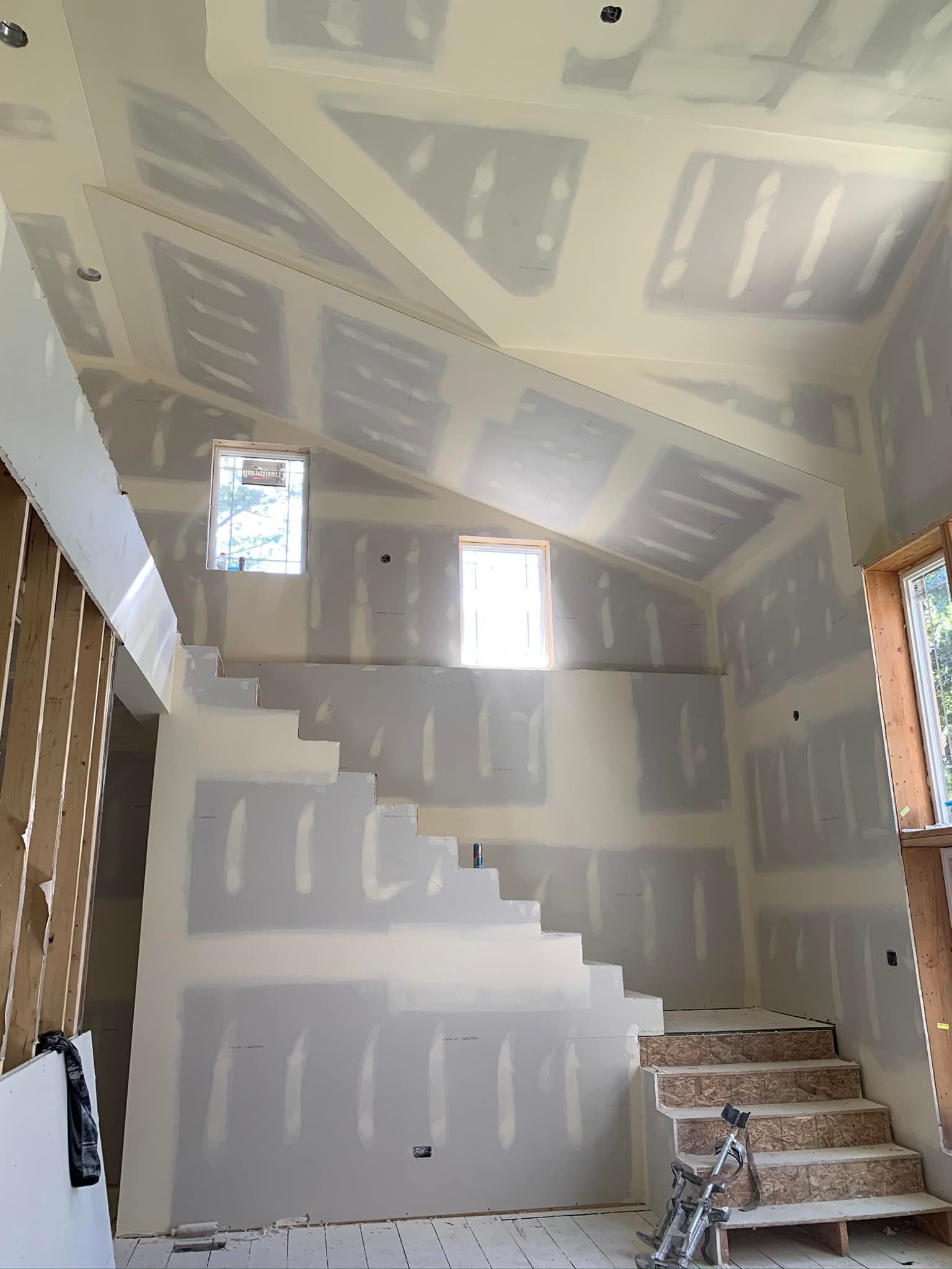 A room with stairs and a vaulted ceiling
