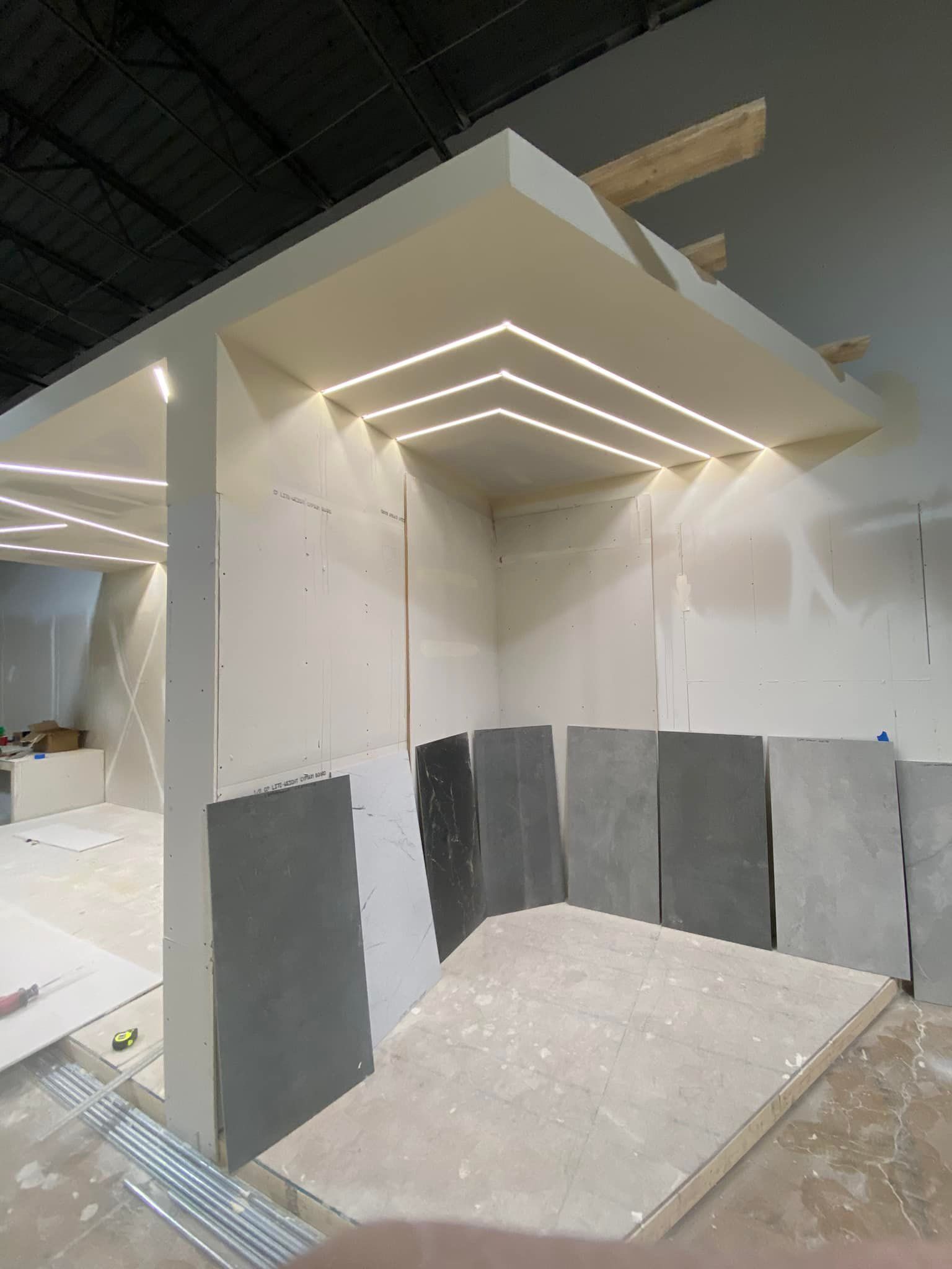 A room with a lot of tiles and a ceiling that is being built.