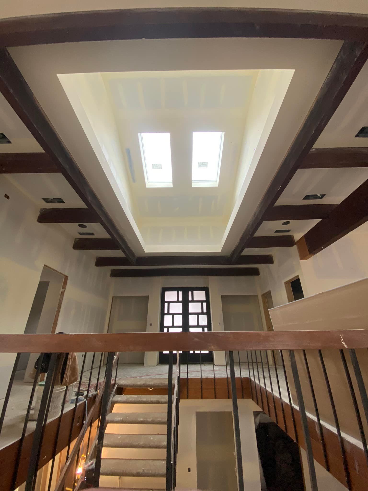 A large room with stairs and a skylight in the ceiling.