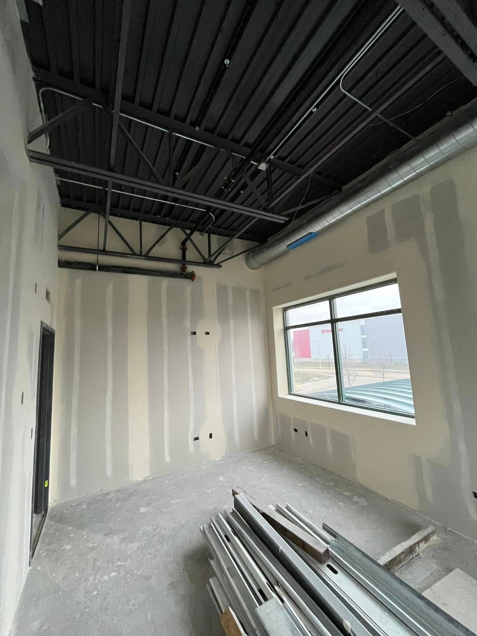 A room with a ceiling and a window in a building under construction.