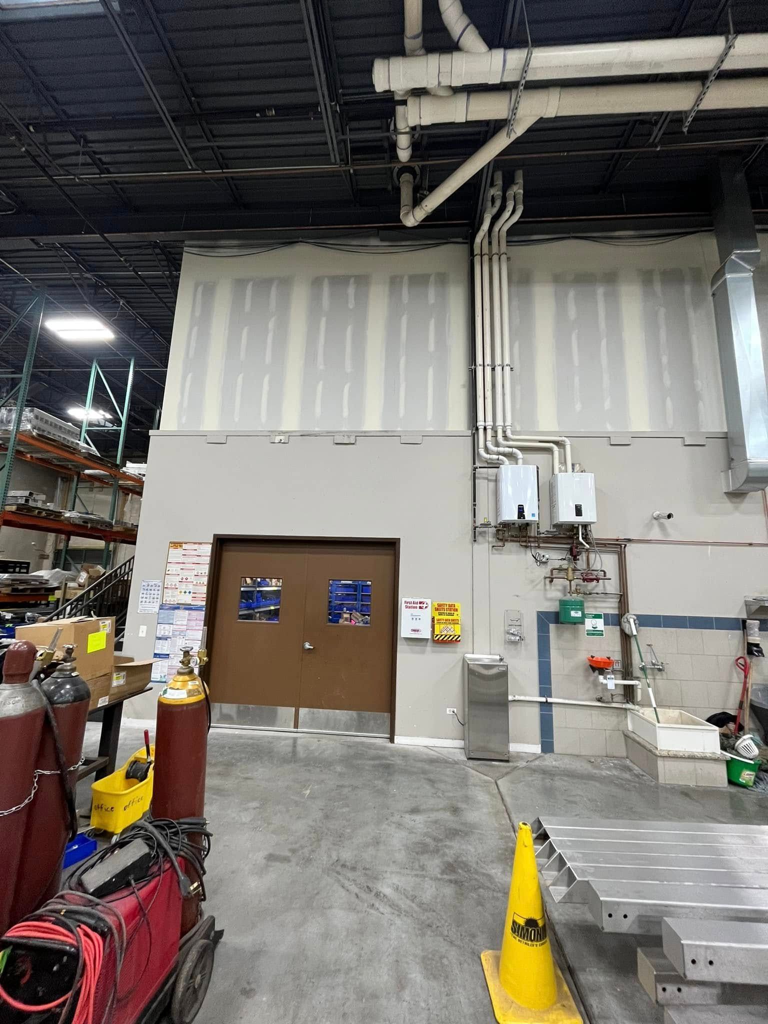 A warehouse with a lot of pipes and a door.