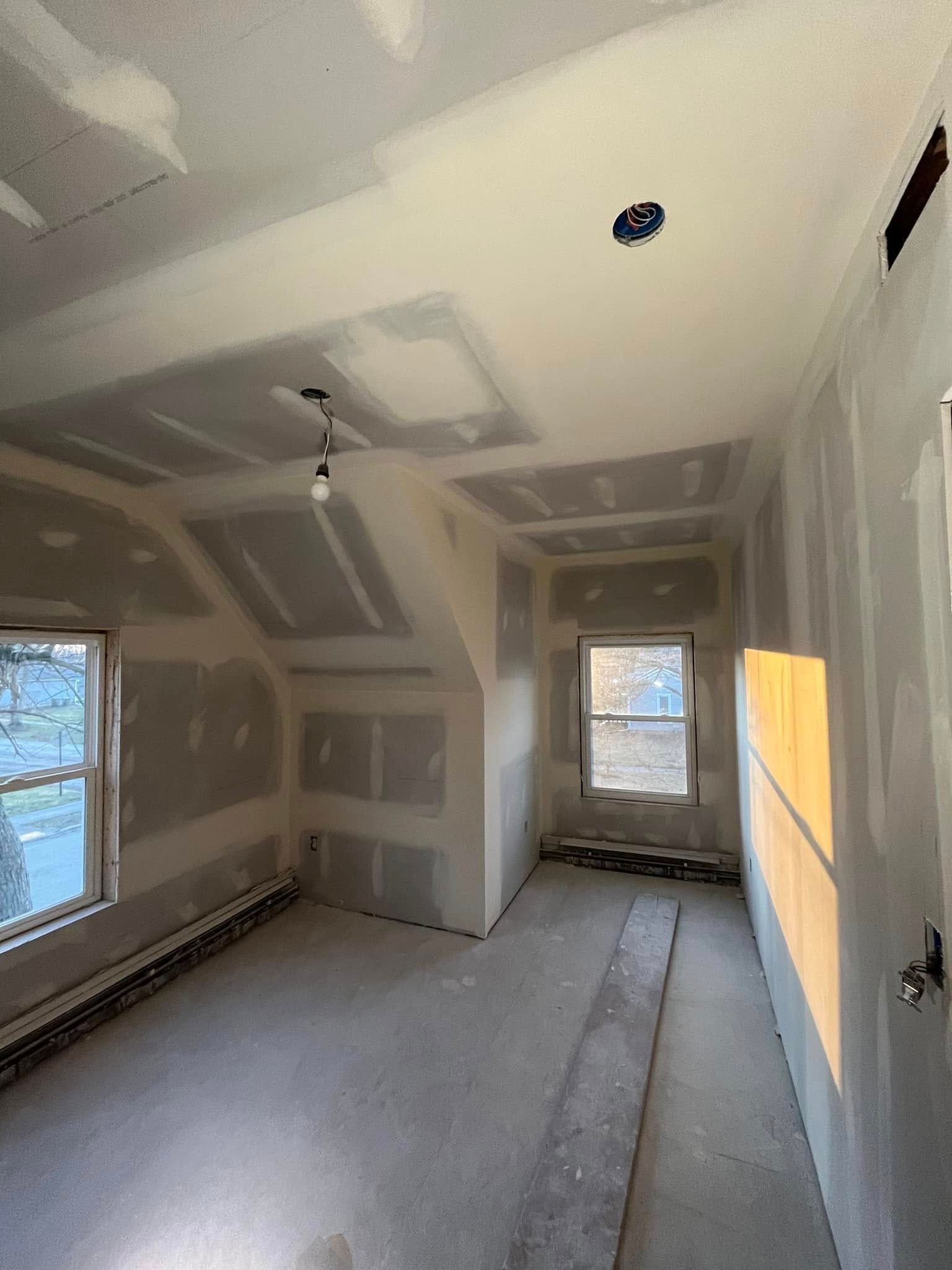 A room that is being remodeled with drywall and a window.