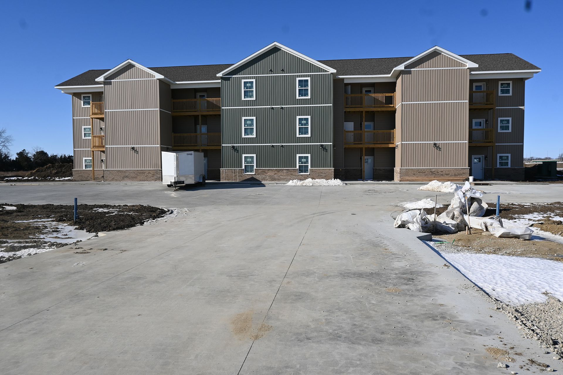 A large apartment building with a concrete driveway in front of it