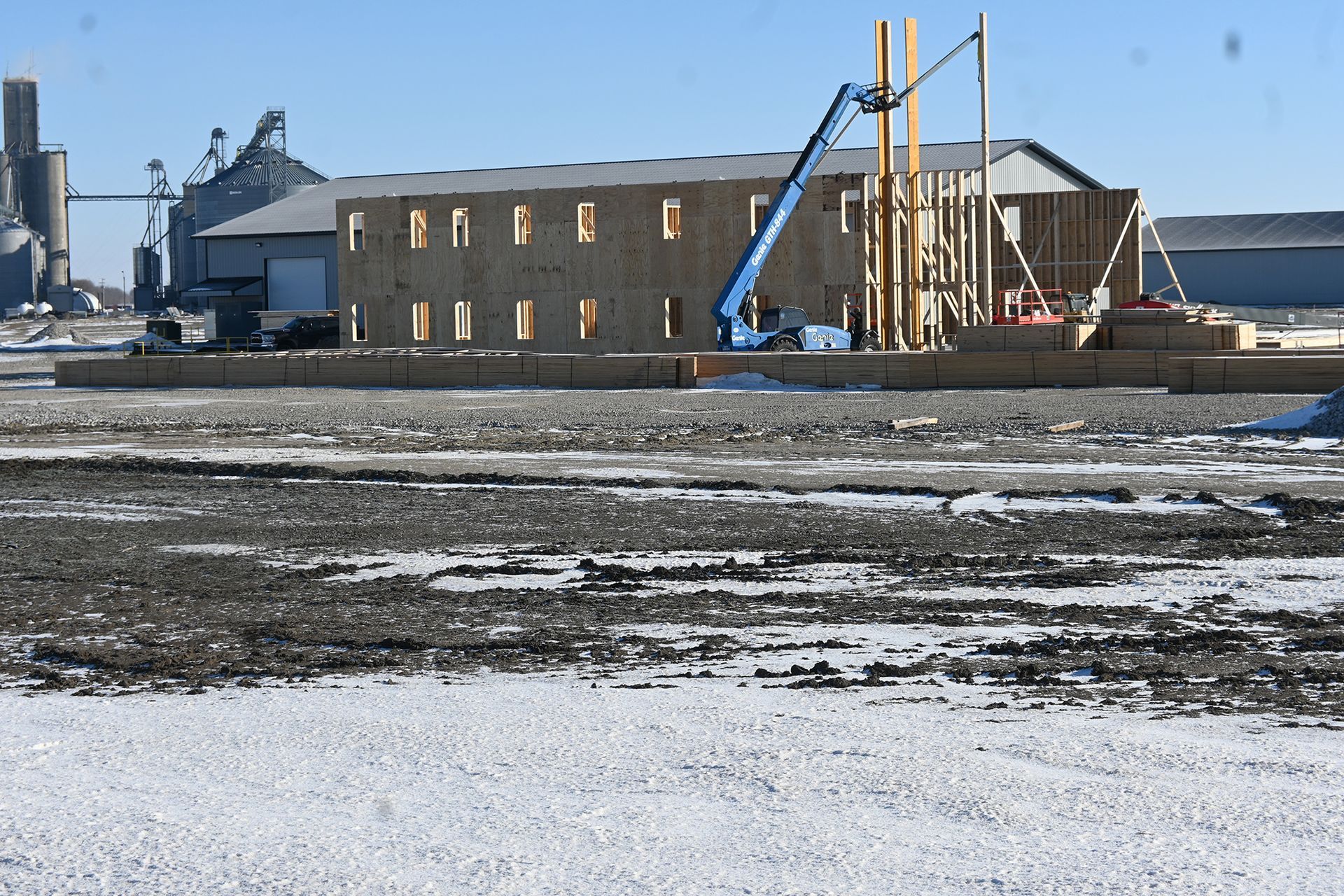 A large building is being built in the middle of a snowy field.