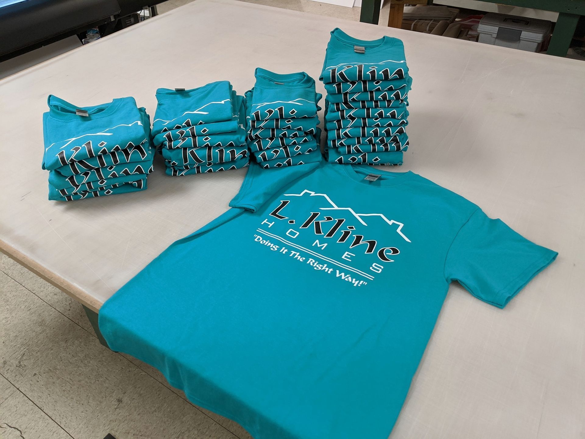 A stack of t-shirts on a table with one that says lklive on it