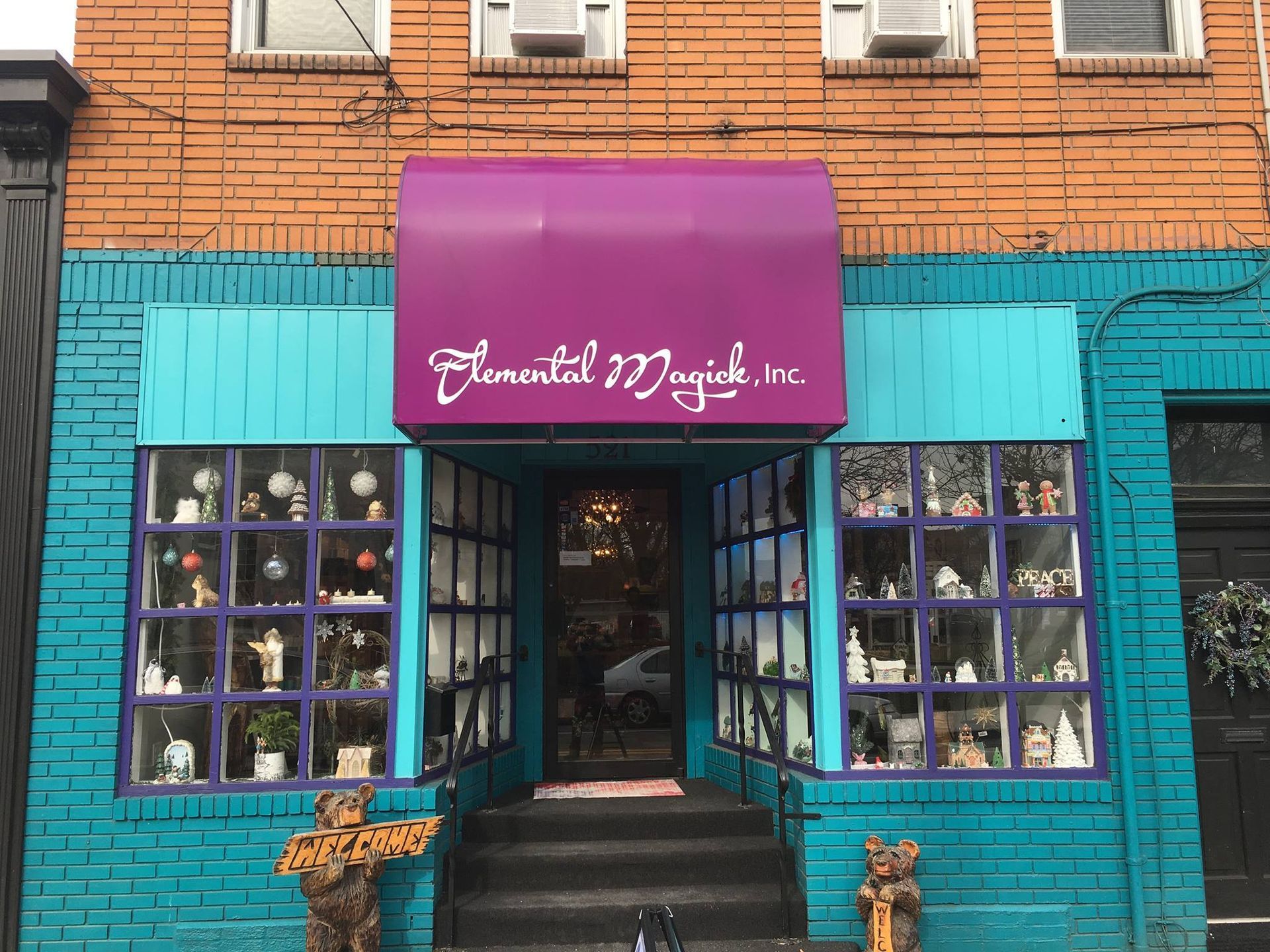A store front with a purple awning and a blue building