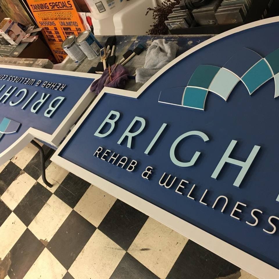 A brigh rehab and wellness sign on a checkered floor