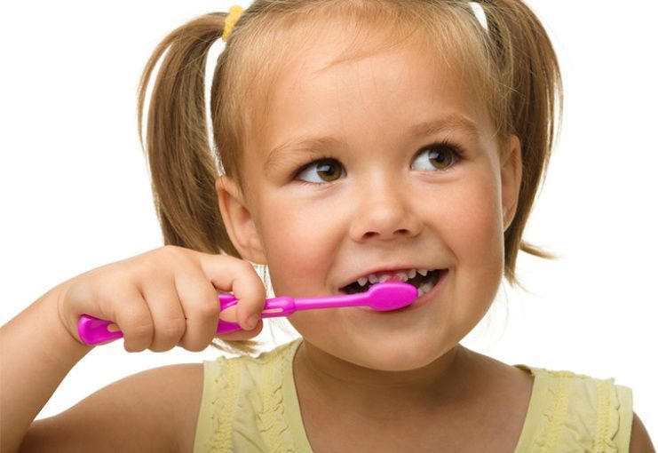 Happy little girl standing with toothbrush