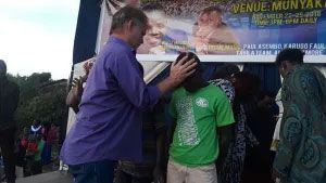 A man blessing a child at a festival.