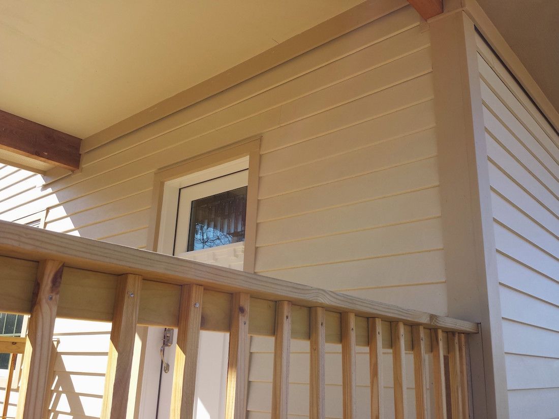 A white house with a wooden railing and a window
