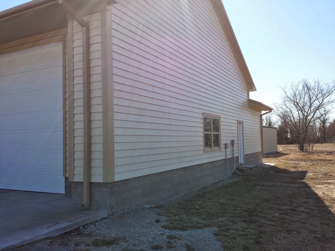 The side of a house with a garage and a window.