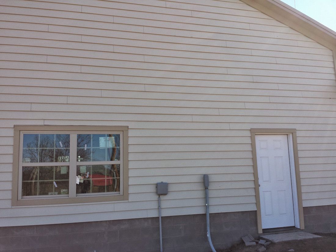 A white house with a white door and two windows.