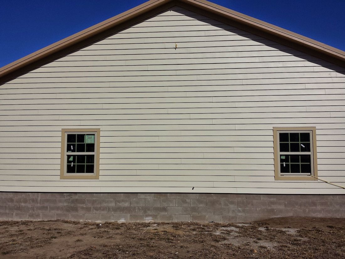 A white house with two windows and a blue sky in the background