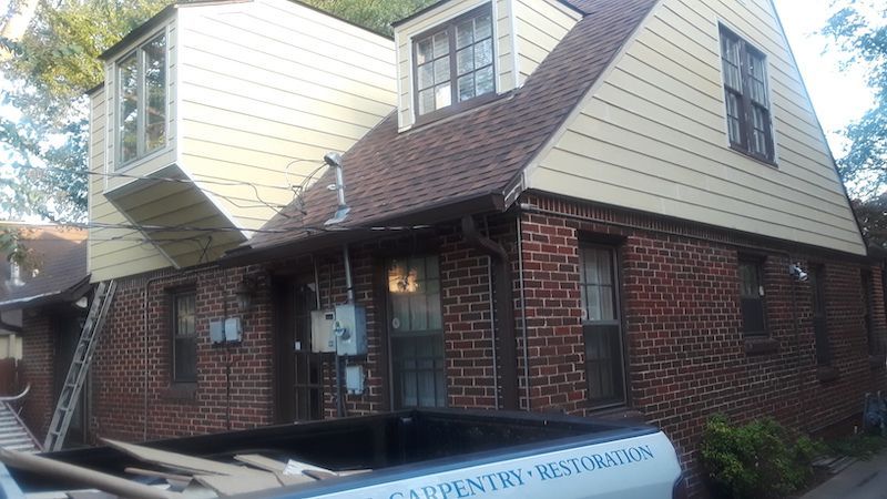 A brick house with a white truck parked in front of it.