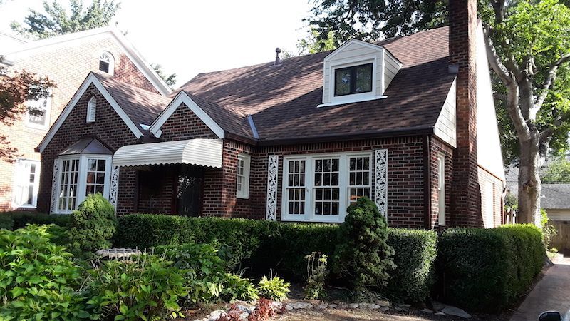 A brick house with a white awning on the porch