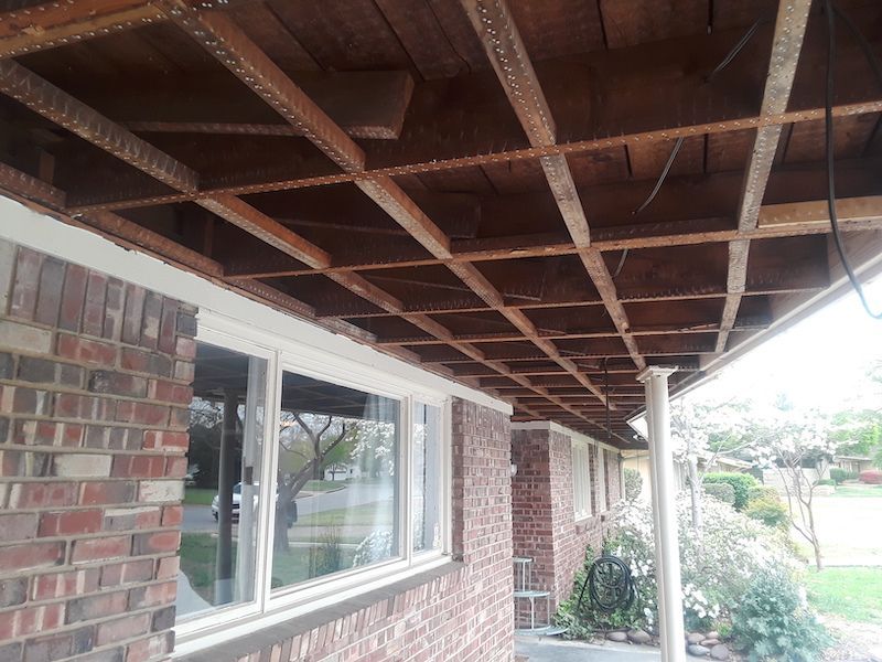 A brick house with a wooden porch underneath it