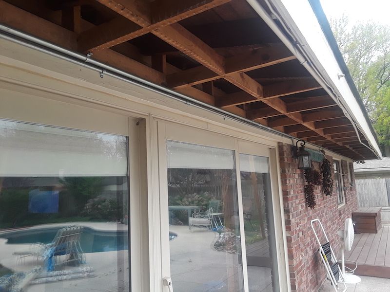 A house with a sliding glass door and a pool in the background.