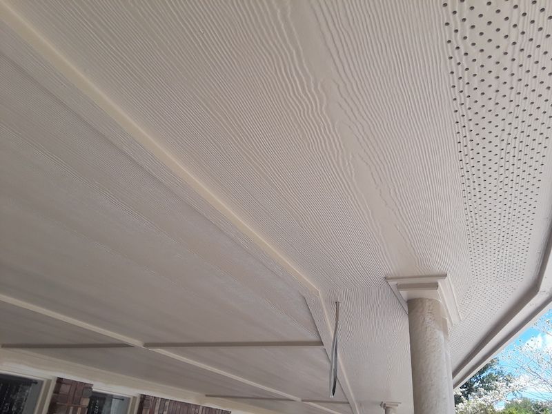 A white ceiling with holes in it is on a porch.