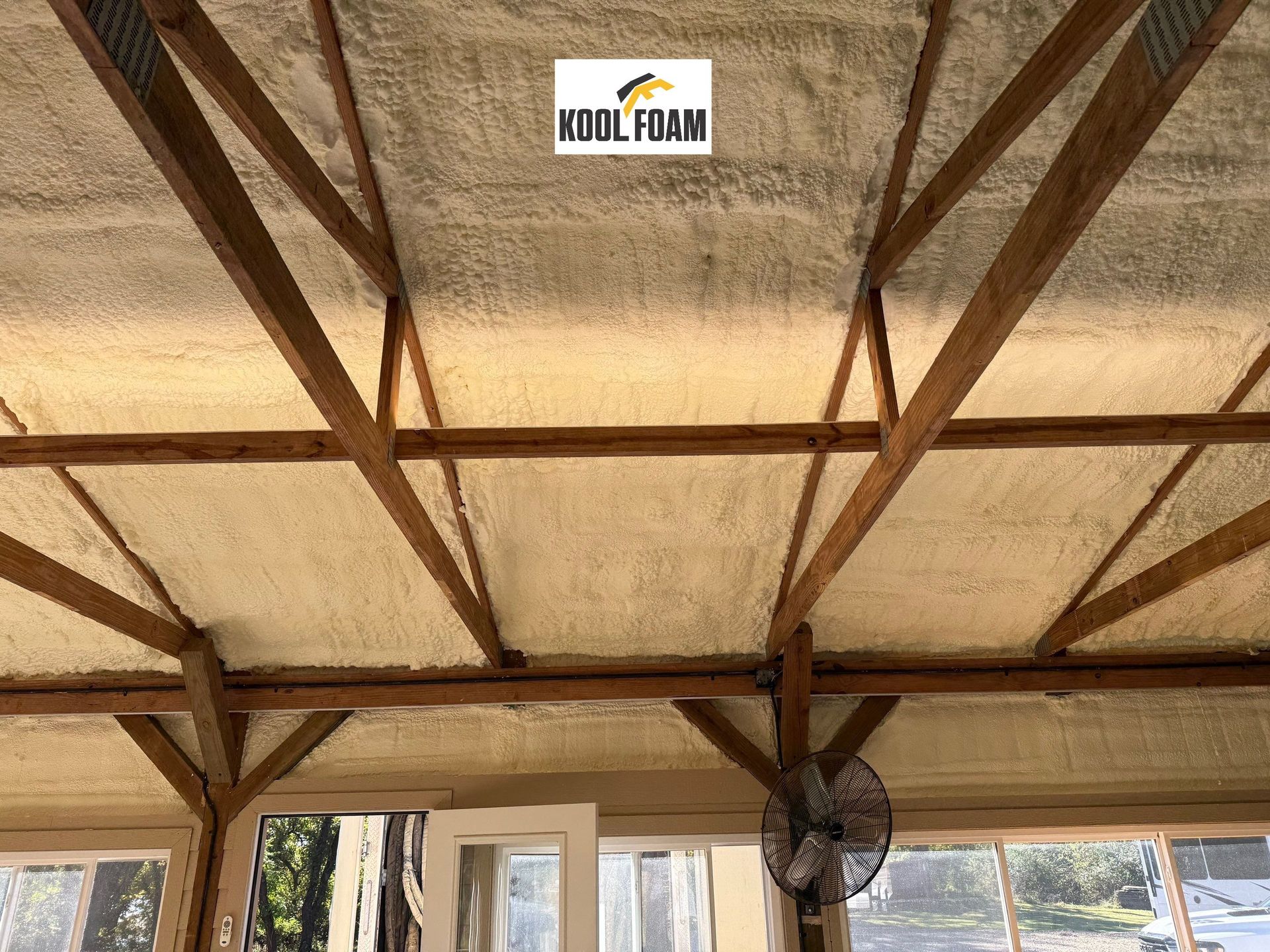 Kool Foam LLC spraying closed cell foam against metal wall in Oklahoma barndominium