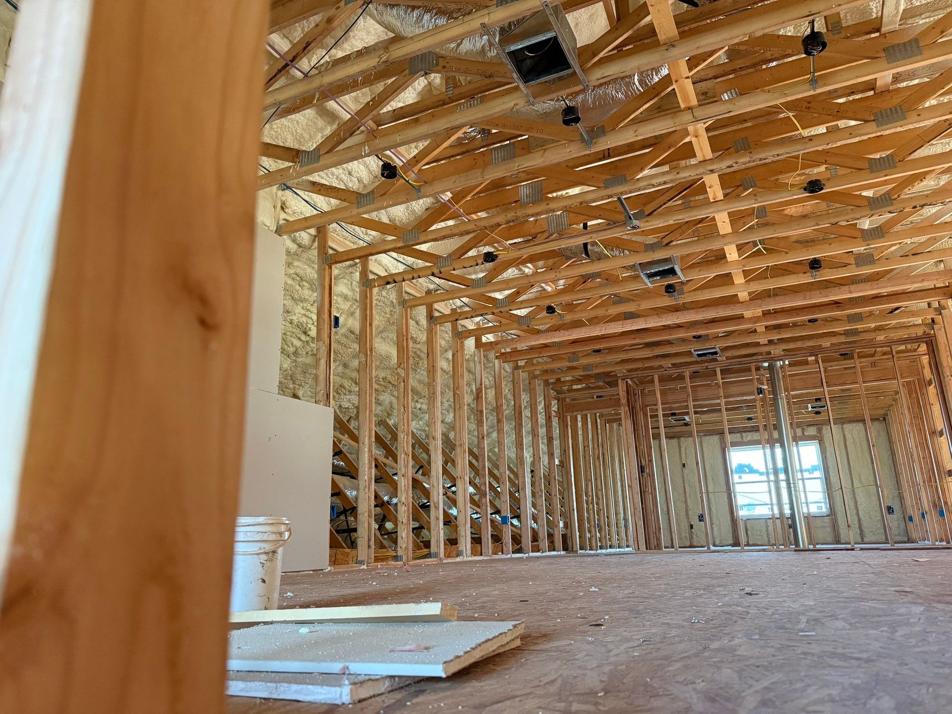 Interior view of a building under construction, showing wooden framing for walls and ceiling.