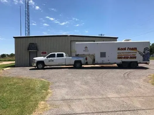 White pickup truck towing a trailer labeled 
