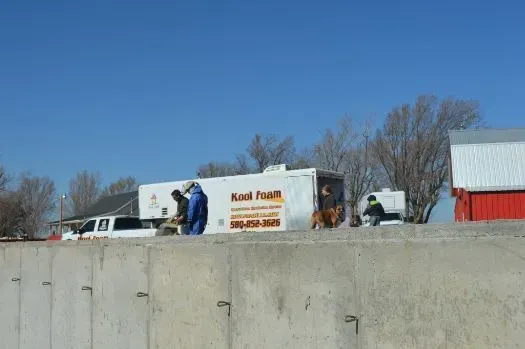 Workers near a white mobile unit with 