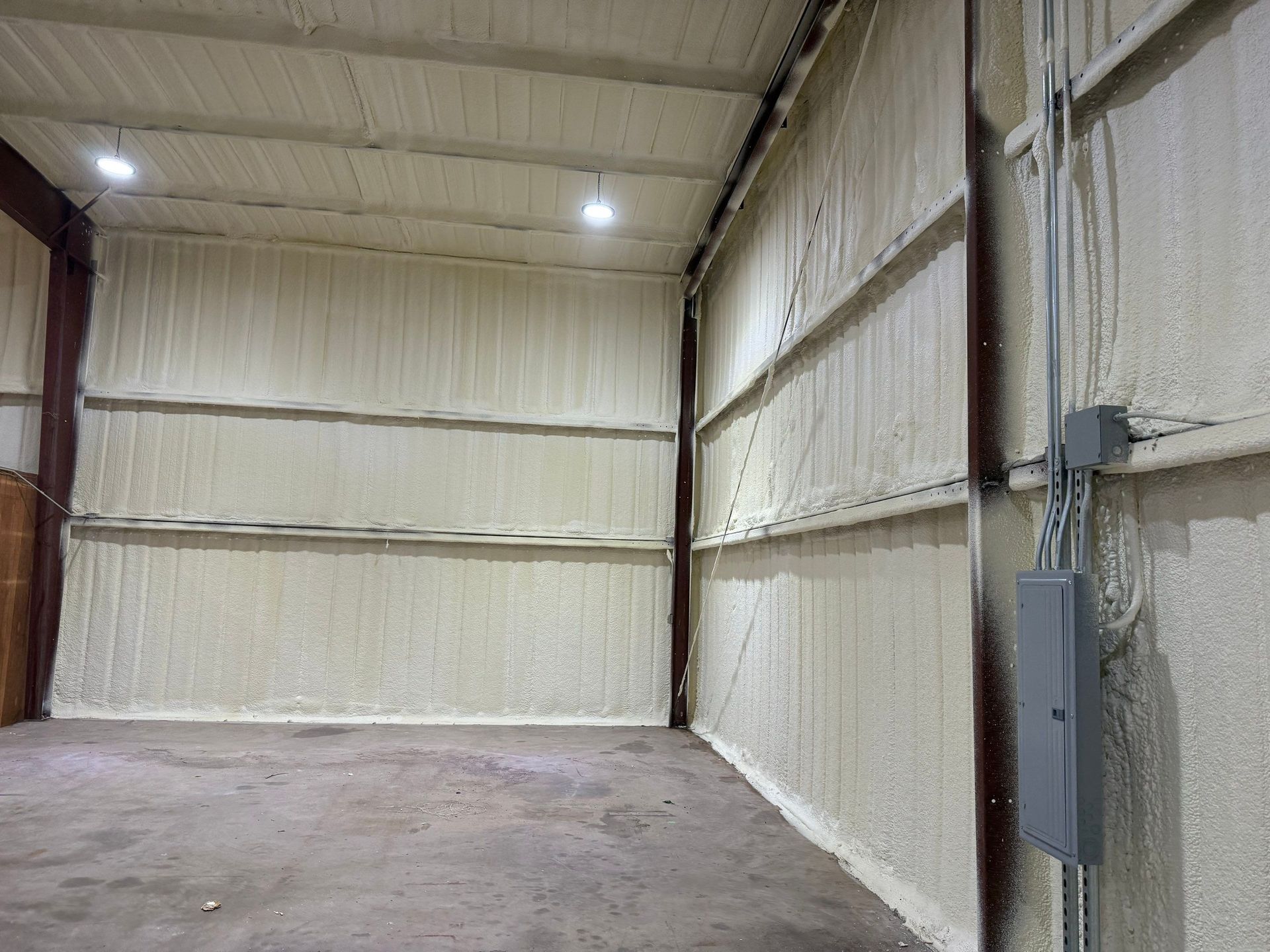 Interior of a metal building with spray foam insulation on the walls and ceiling.