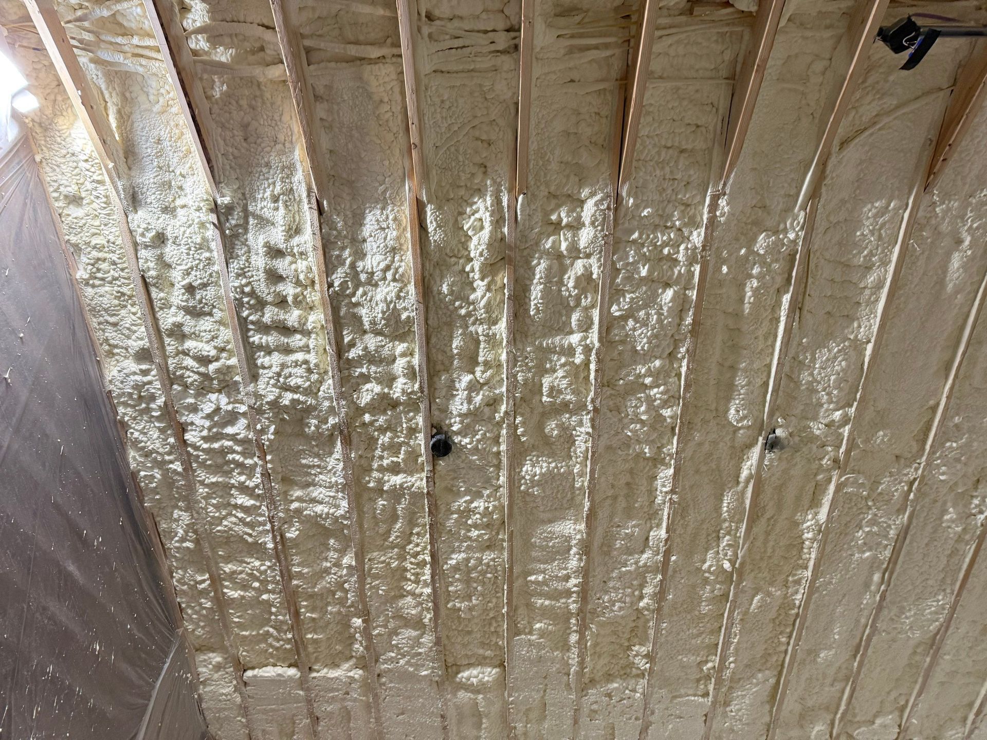 Wooden ceiling beams with spray foam insulation.