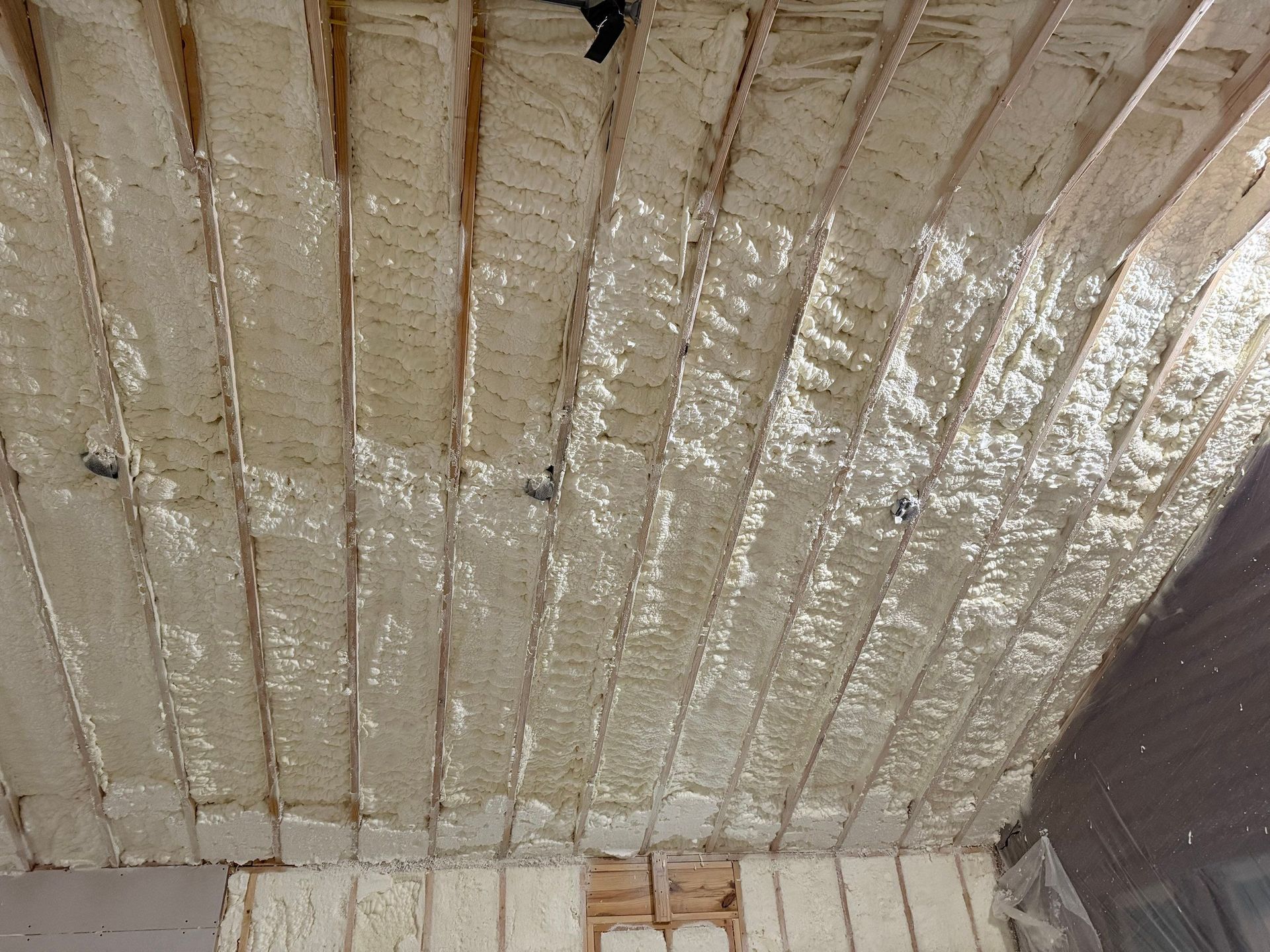Wooden ceiling beams with spray foam insulation.