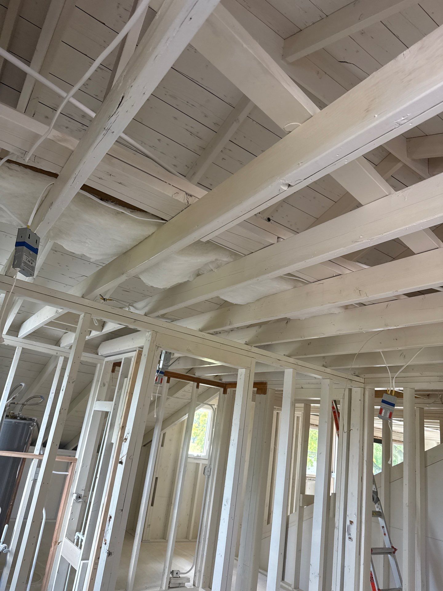 Interior view of a building under construction, showing wooden framing for walls and ceiling.