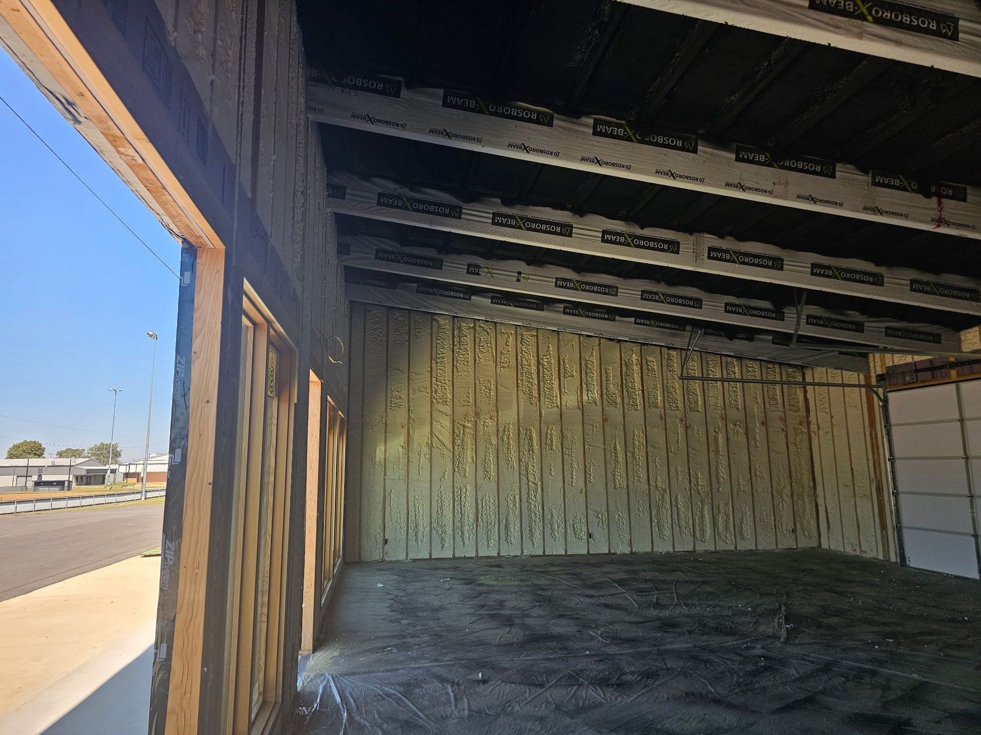Interior of a building under construction. The walls and ceiling are exposed wood and metal.