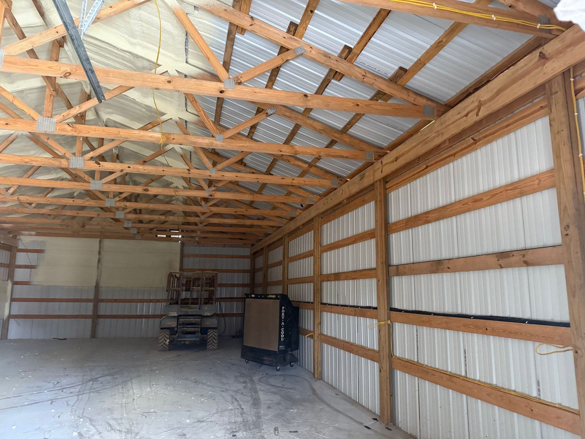 Interior of a pole barn with metal siding and exposed wooden beams.